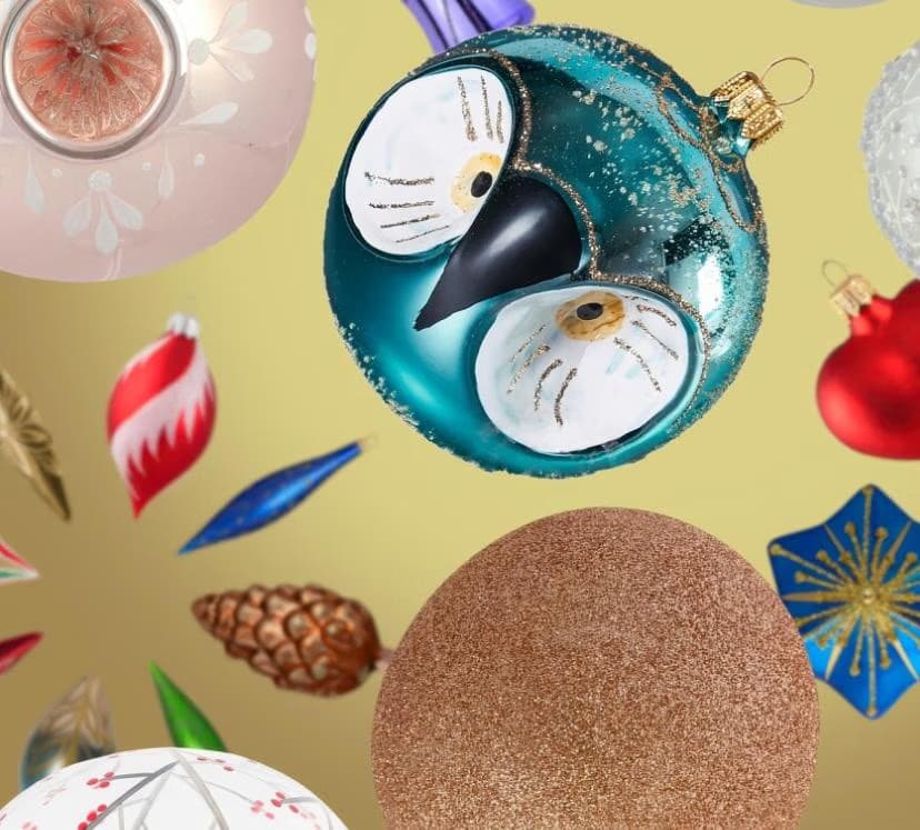Various Christmas tree ornaments float against a solid gold background.