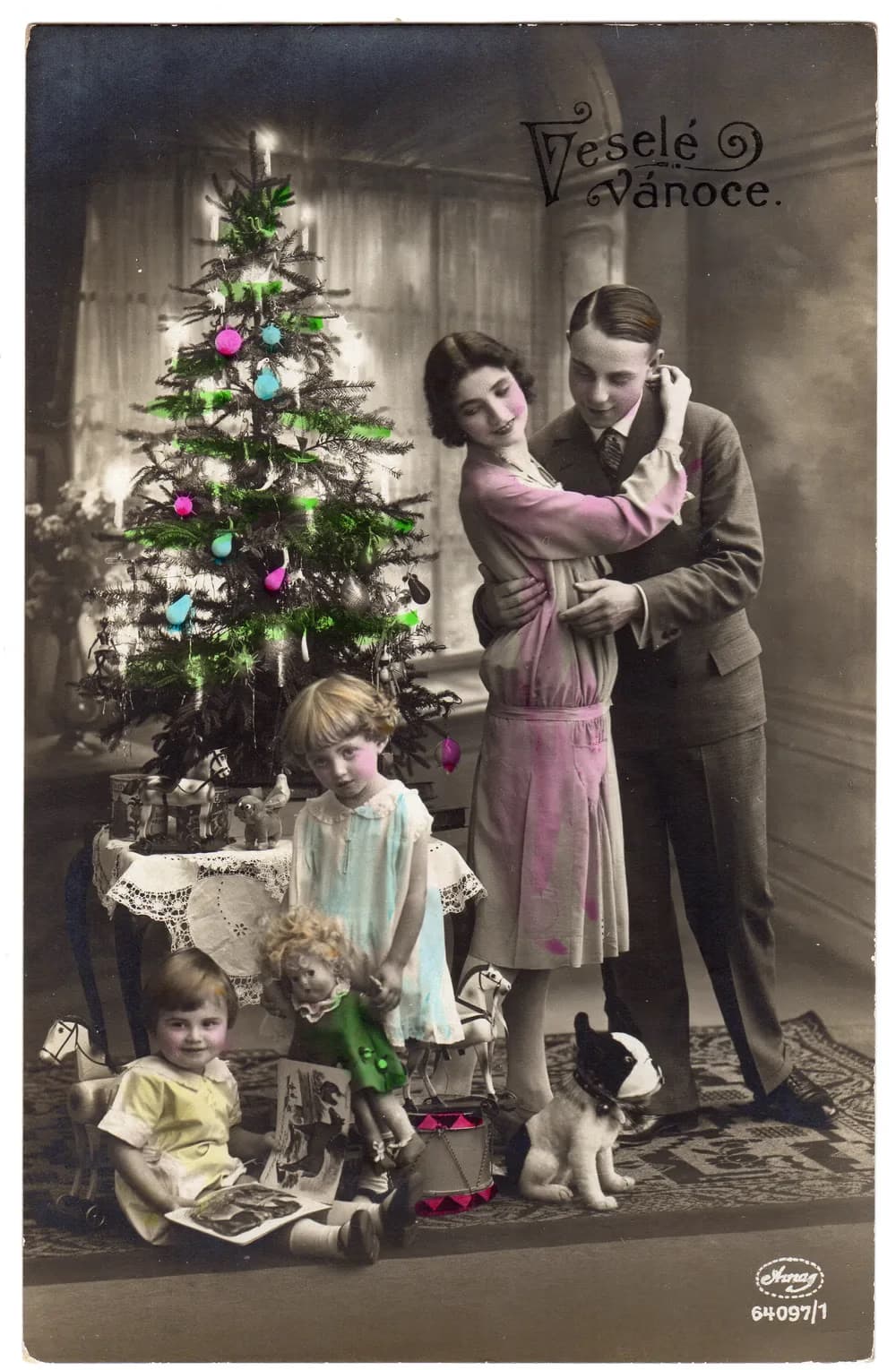 Zabytkowa, kolorowana fotografia rodziny przy choince z dziećmi i zabawkami.