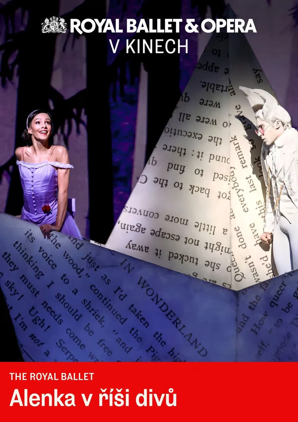 Ballerinas perform in a theatrical scene with oversized paper props featuring printed text.