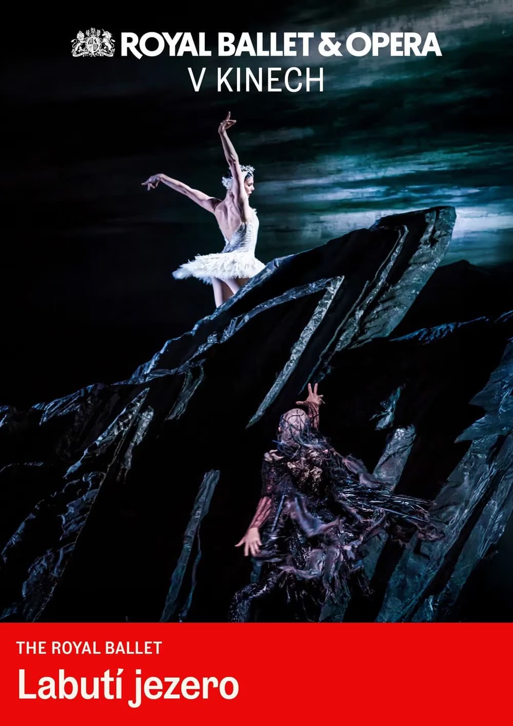 A ballerina and another figure perform on stage in a dark scene from Swan Lake.