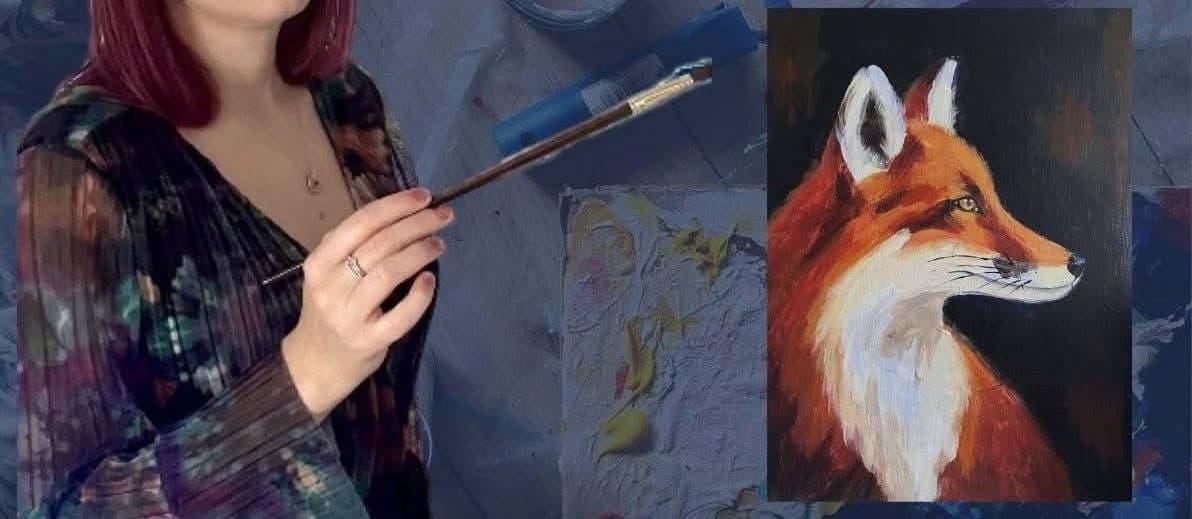 An artist holds a paintbrush in front of a painting of a red fox.