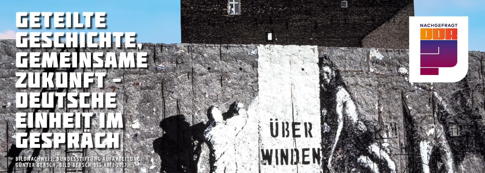 Graffiti on a Berlin Wall section with overlaid German text and a colorful event logo.