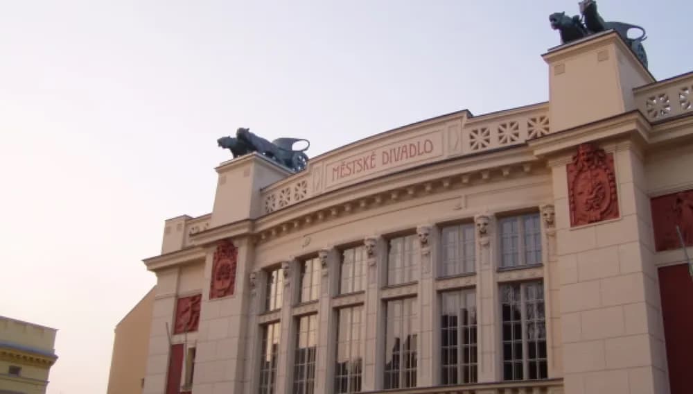 Die obere Fassade des Stadttheaters mit Skulpturen an den Dachecken.