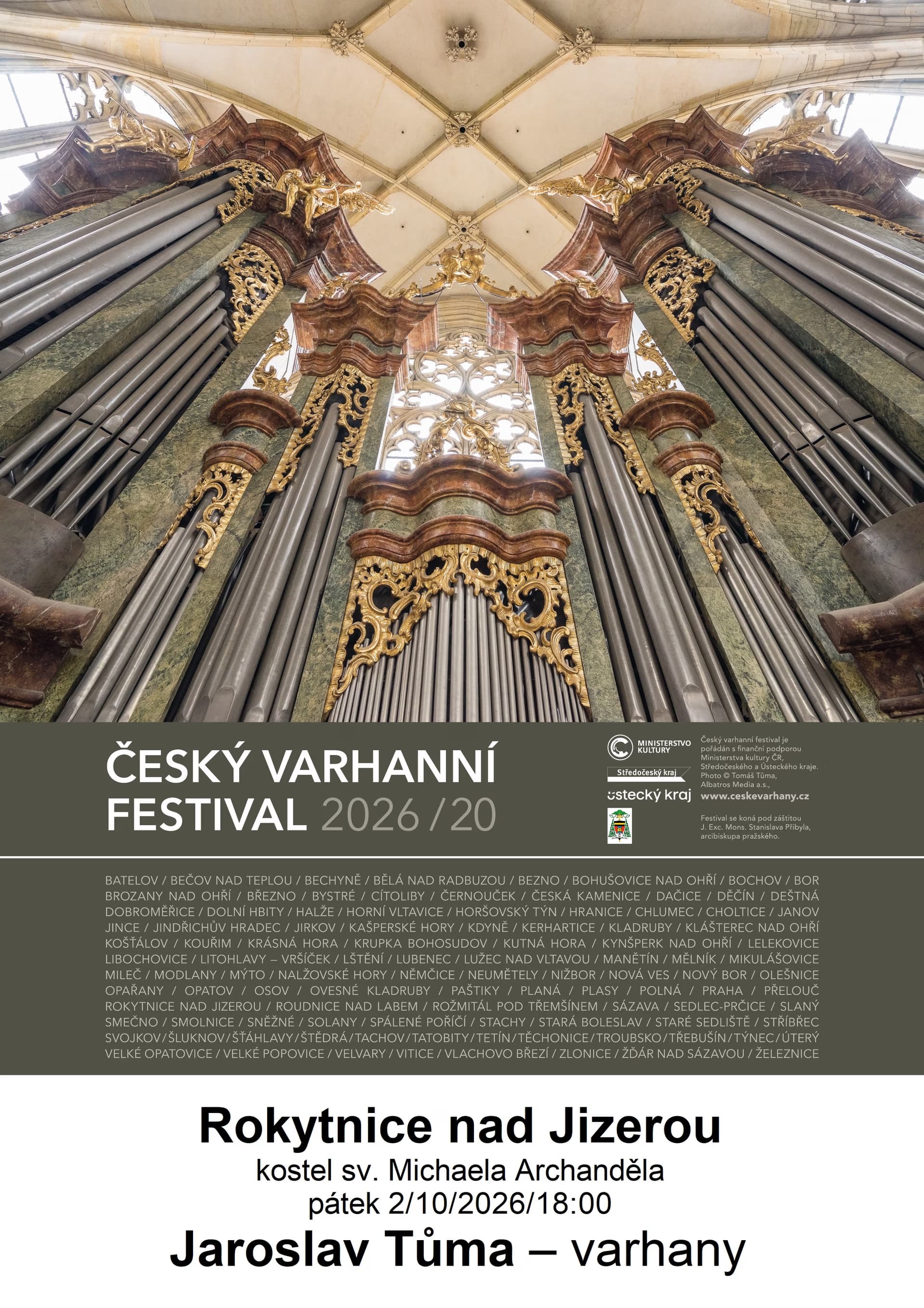 Looking up at ornate pipe organ pipes inside an elaborate baroque church interior.