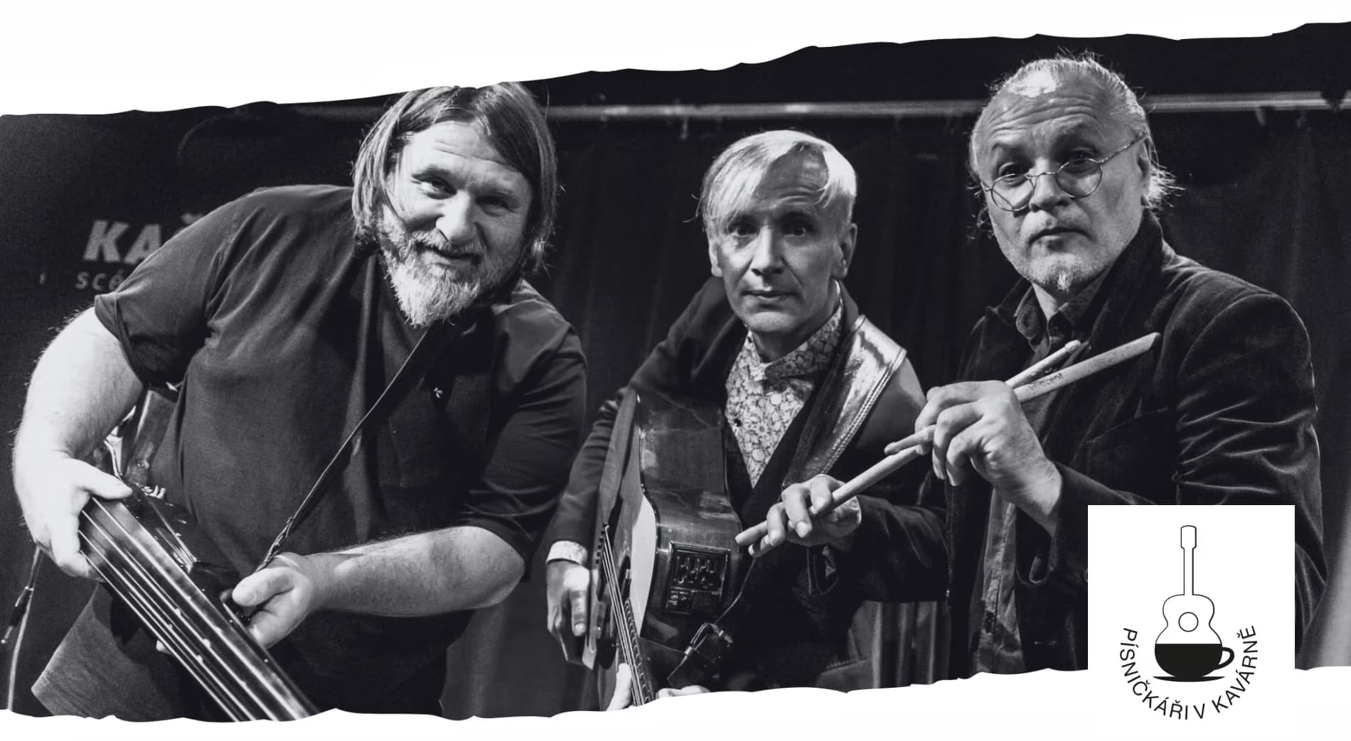 Three musicians holding instruments stand on a stage in front of a dark backdrop.
