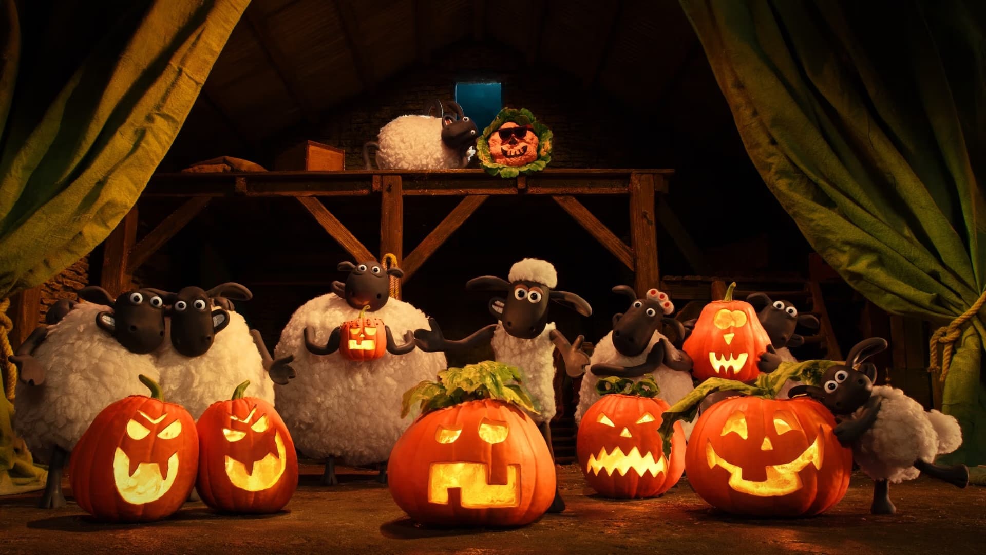 Postacie z bajki Shaun the Sheep stoją pośród świecących dyń w ciemnej, rustykalnej stodole.