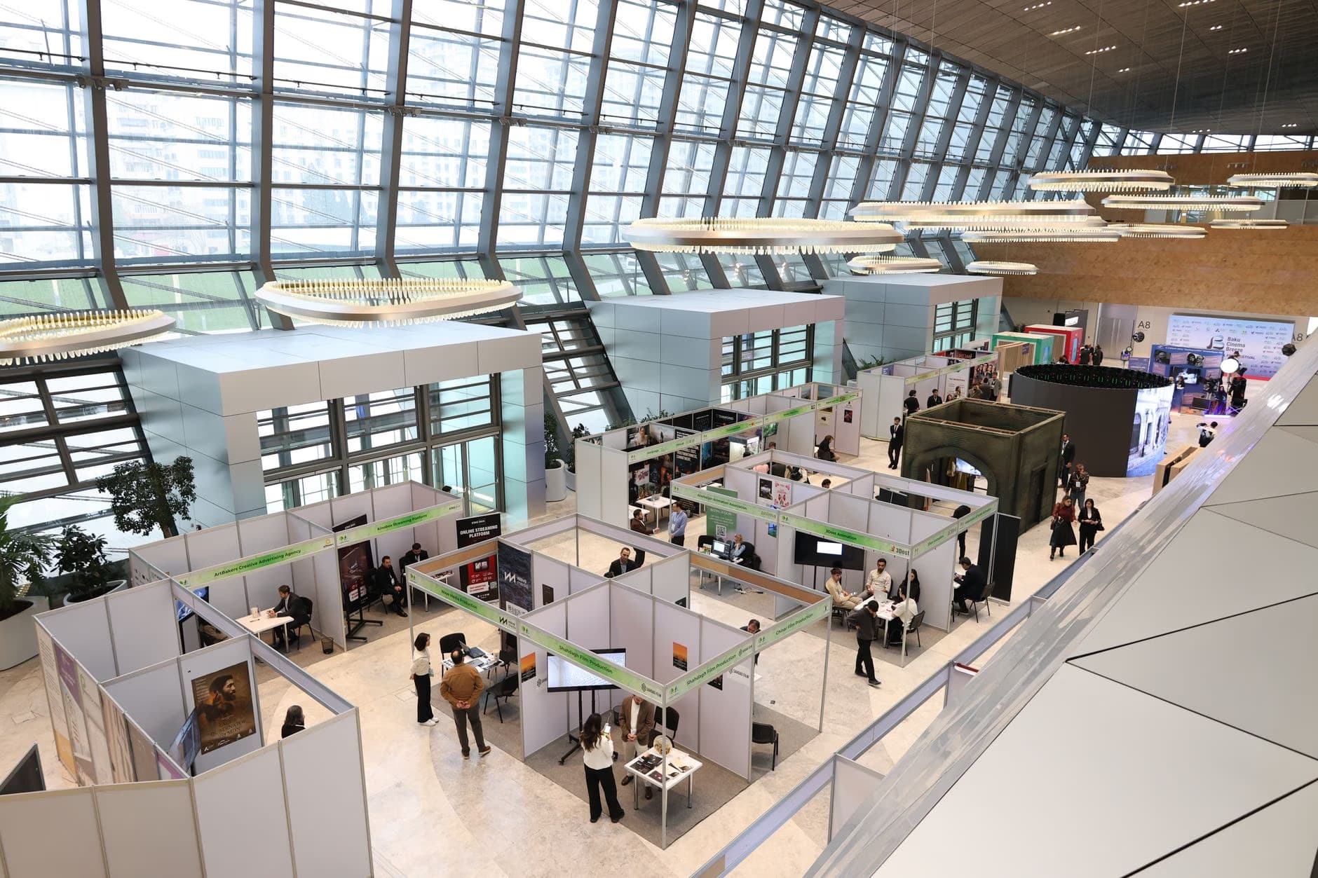 High angle view of a modern trade fair or exhibition hall with numerous white vendor booths.