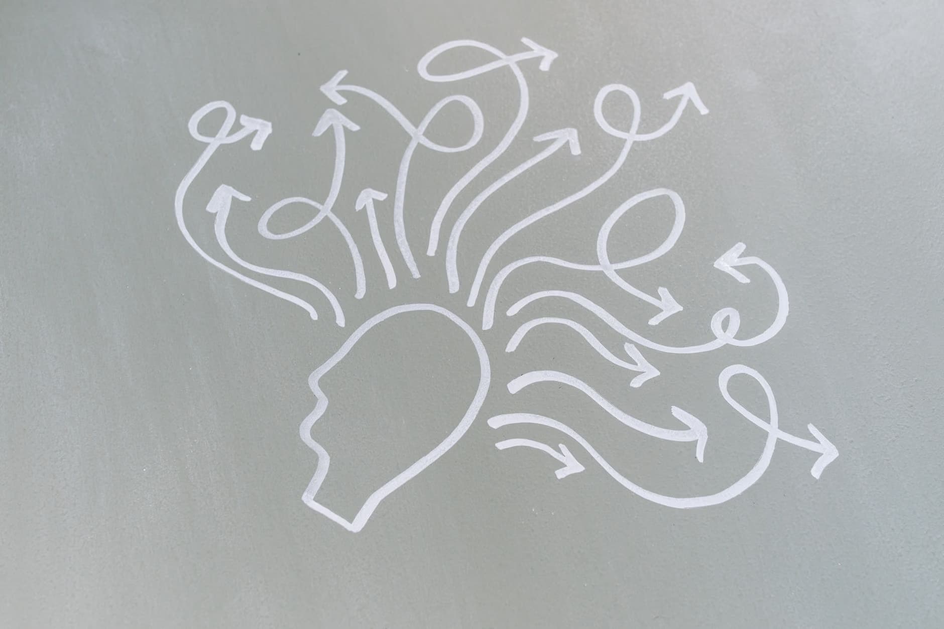 Minimalist white line drawing of a human head with multiple arrows radiating outward.