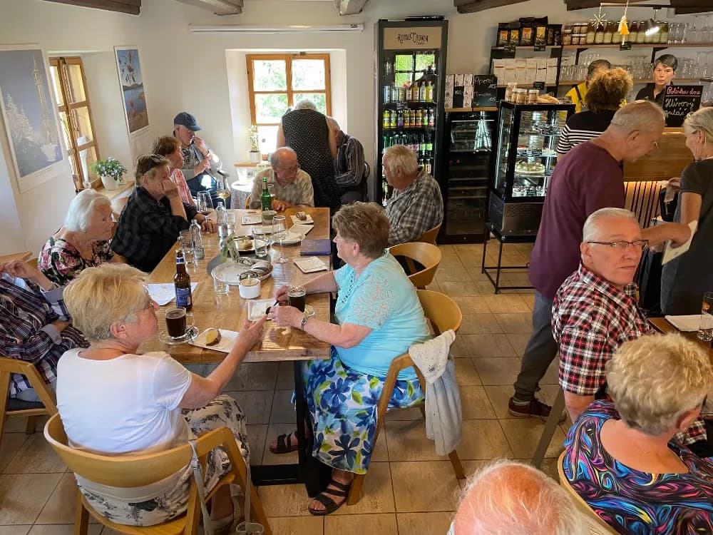 A group of people dining and chatting together in a cozy restaurant or cafe setting.