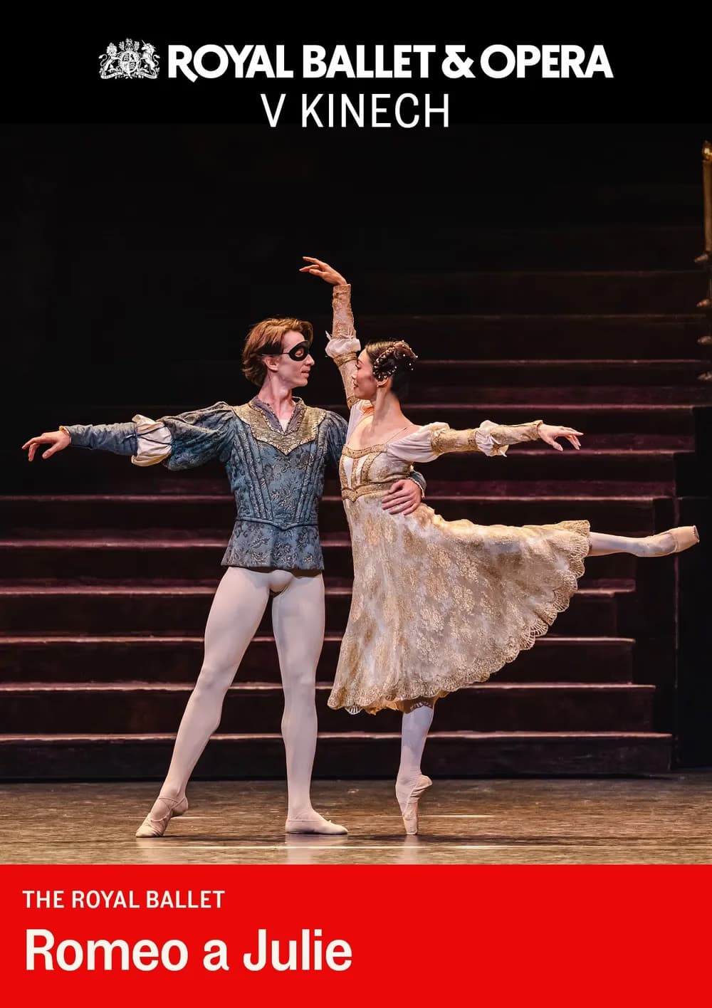 Two ballet dancers in period costumes perform Romeo and Juliet on a dark stage.