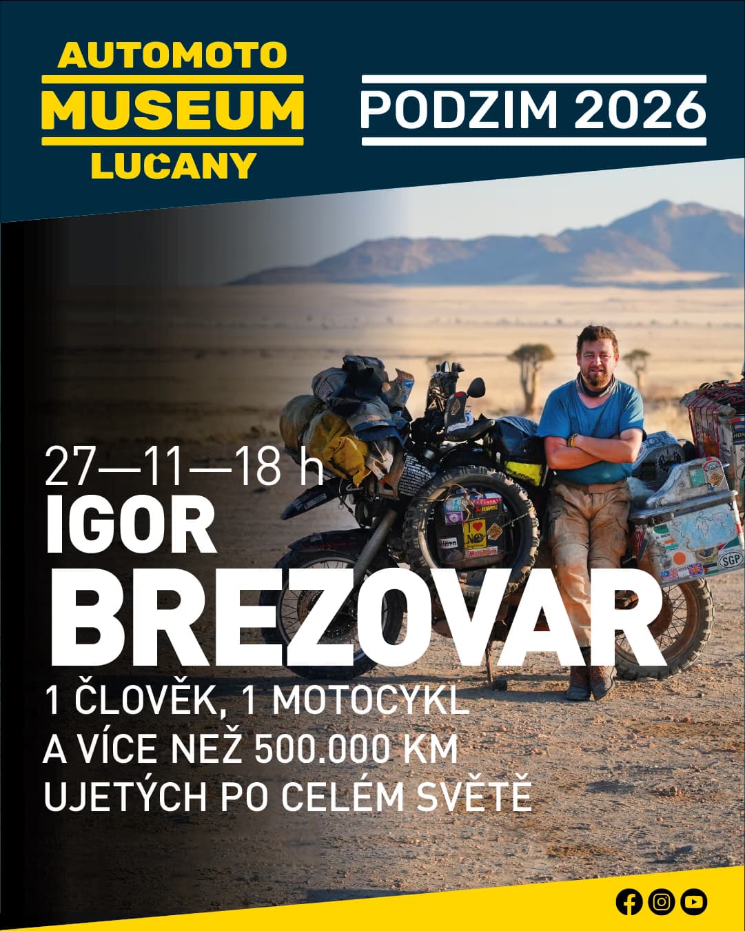 Motocyklista stojí vedle plně naložené cestovní motorky v suché, pouštní krajině.