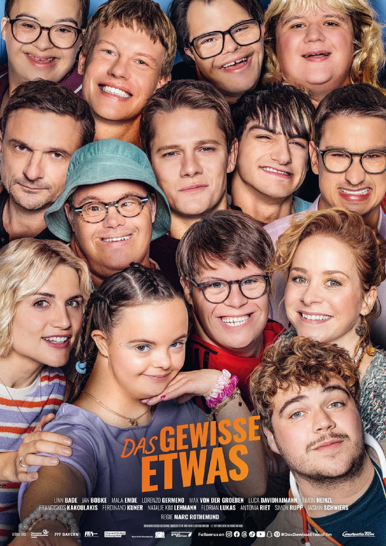 Eine Gruppe vielfältiger Schauspieler lächelt gemeinsam auf einem Filmplakat.