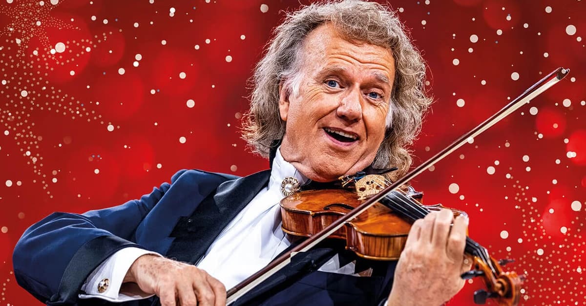 André Rieu playing the violin against a festive red background with sparkling lights.