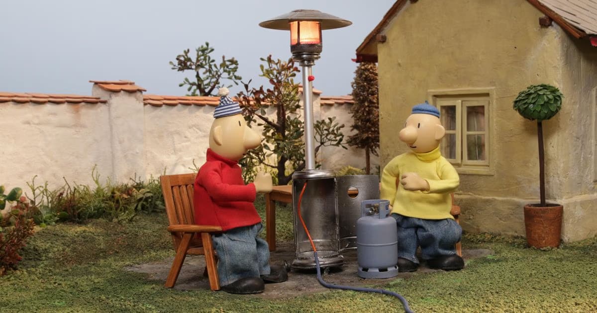 The stop-motion characters Pat and Mat sit outdoors in a garden next to a patio heater.