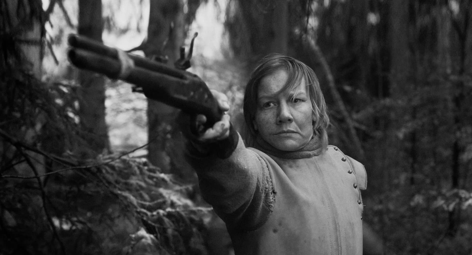A person in historical costume aims a flintlock pistol forward within a forest setting.