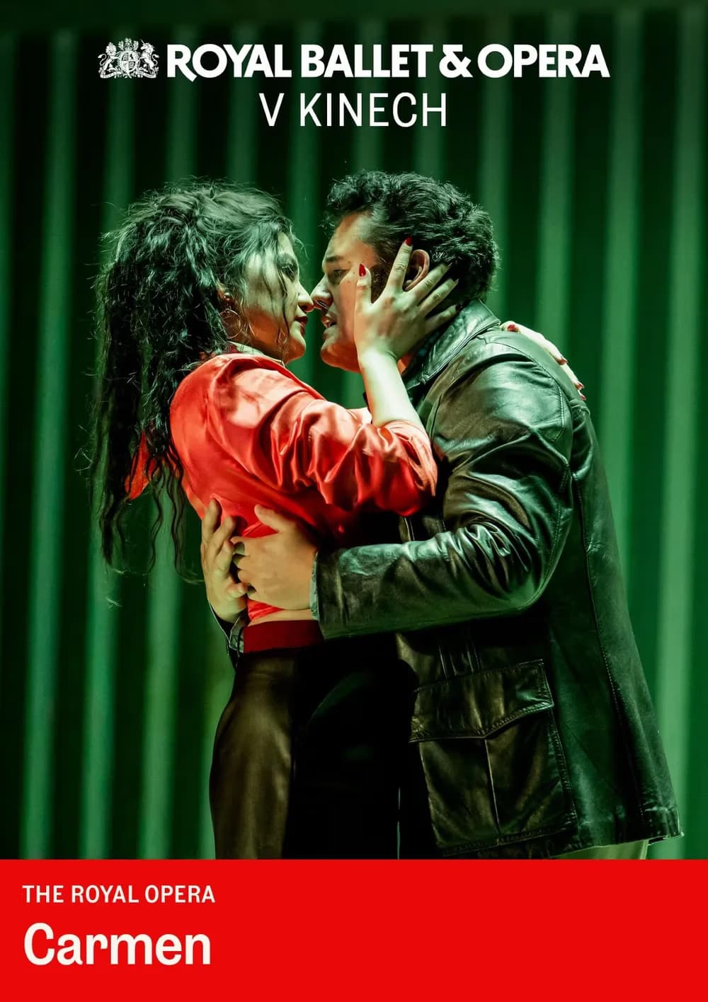 A woman in a red top embraces a man in a leather jacket against a green backdrop.